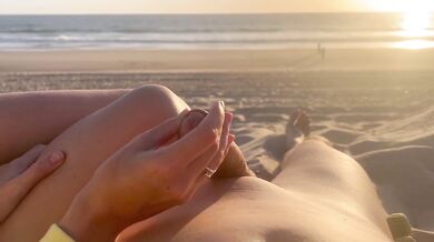 Public handjob on a nude beach caught at sunset with a cumshot